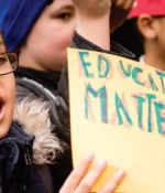 Una niña sostiene un cartel en una manifestación que indica "La educación importa"